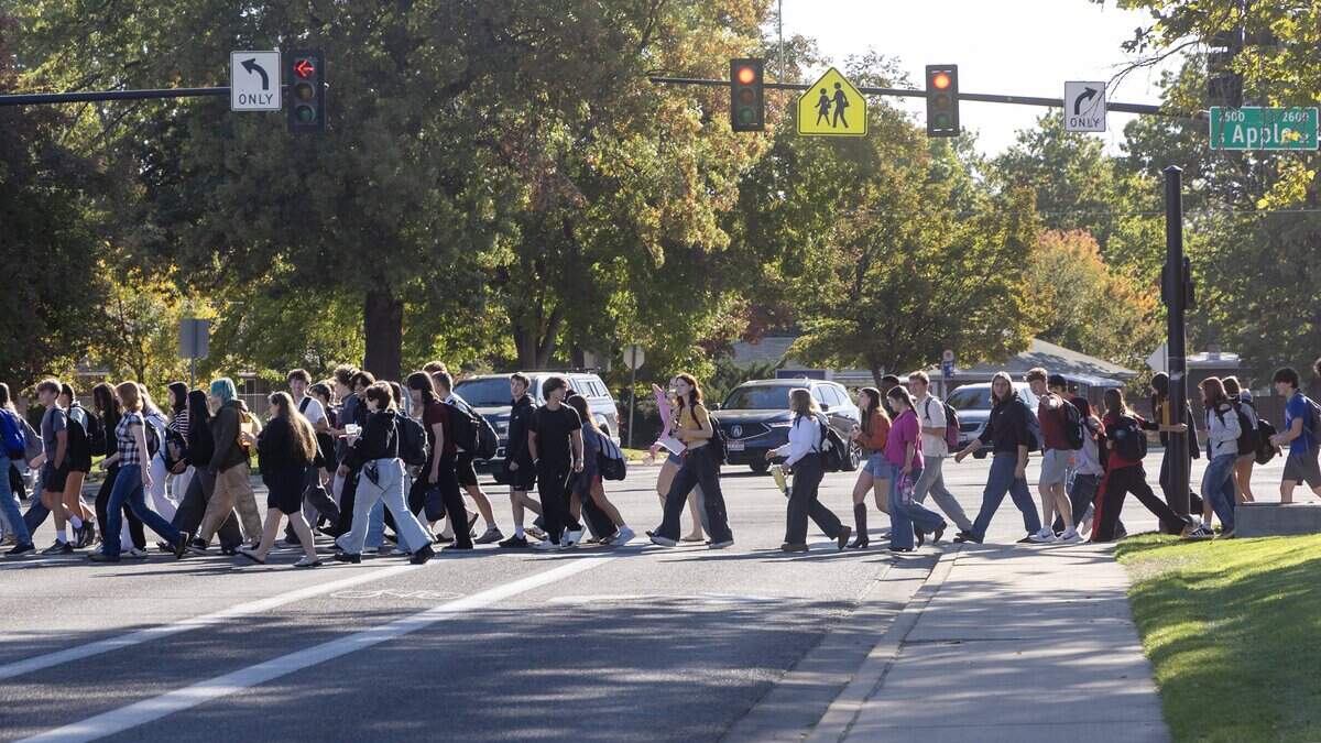 Students cross the street to participate in a walkout at Timberline High School in Boise, Wednesday, October. 7, 2026. The student-led protest was in response to widely-shared screenshots of an alleged group chat between several members of the Timberline High School football team that referenced wanting to rape and kill a female student.