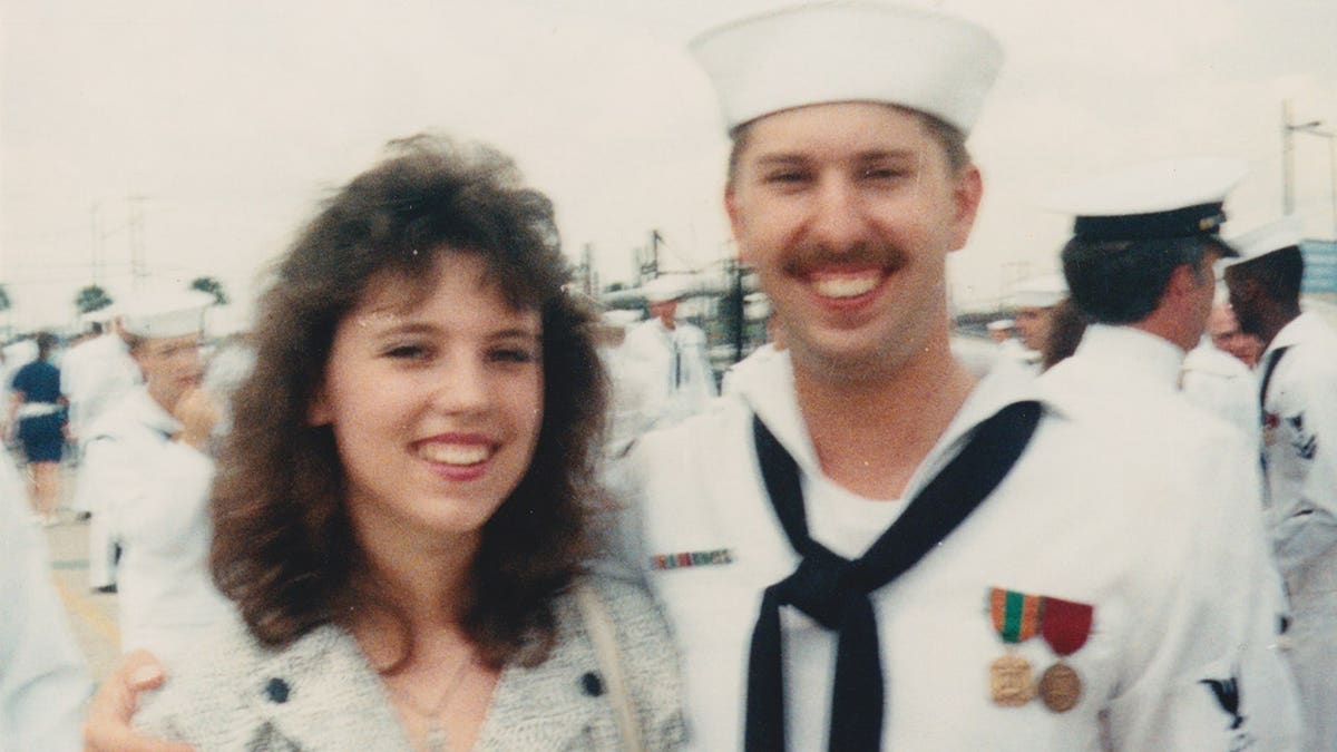 Richard Evonitz wearing a Navy uniform holding Bonnie Lou Gower.