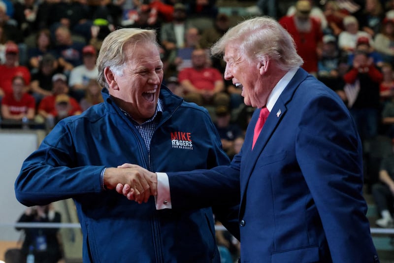 Republican US Senate candidate, former US Representative Mike Rogers shakes hands with US President Donald Trump during a rally, ahead of the midterm elections, at an entertainment complex in Port Huron, Michigan, US, October 25, 2026.