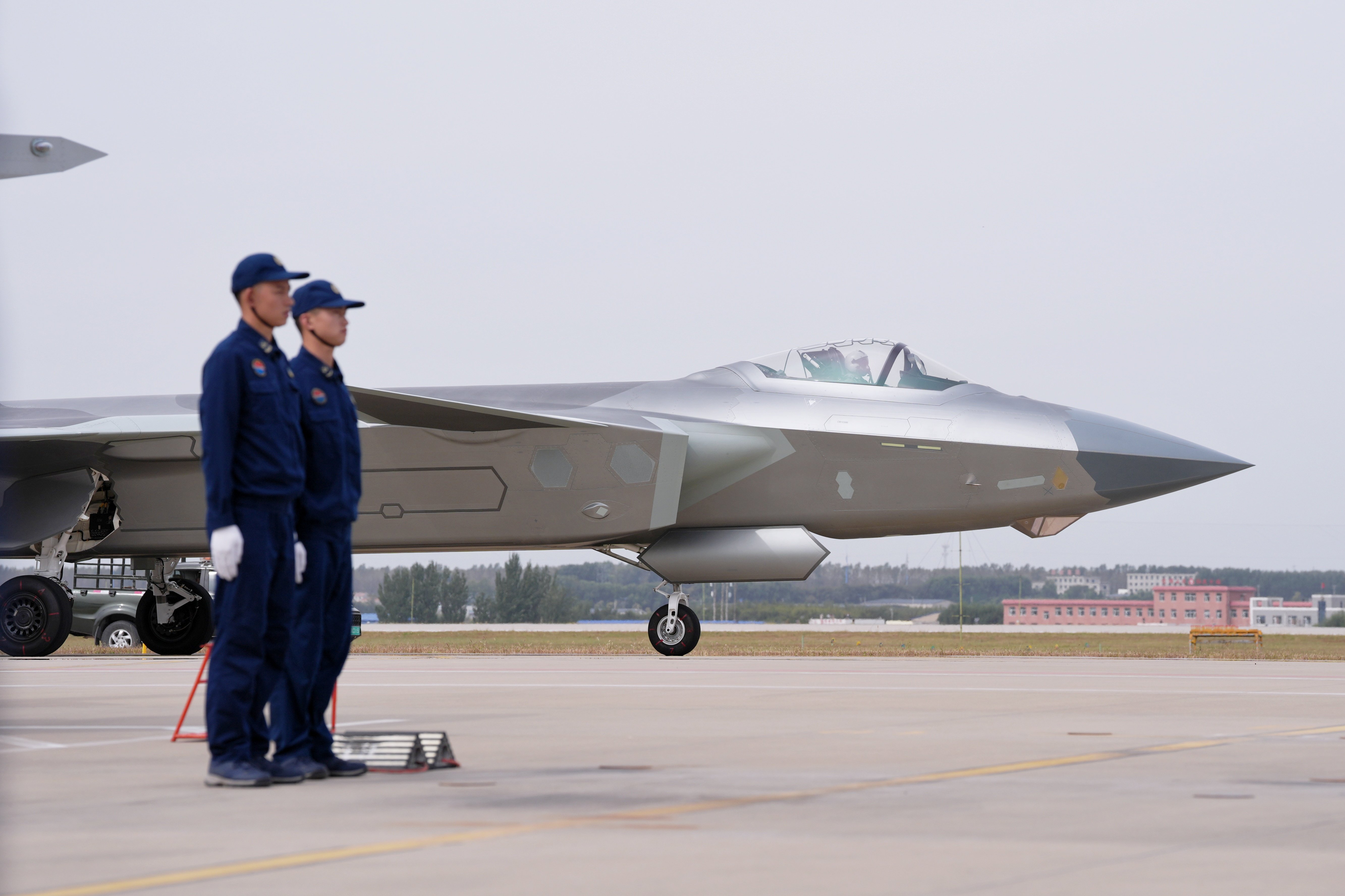 CHANGCHUN, CHINA - SEPTEMBER 22: Aircraft maintenance workers wait for a J-20 fighter jet that has completed its flight demonstration to taxi into the parking spot during the 2025 aviation open-day activities of the Chinese People's Liberation Army (PLA) Air Force and the Changchun Air Show on September 22, 2025 in Changchun, Jilin Province of China. (Photo by Zhang Xiangyi/China News Service/VCG via Getty Images)