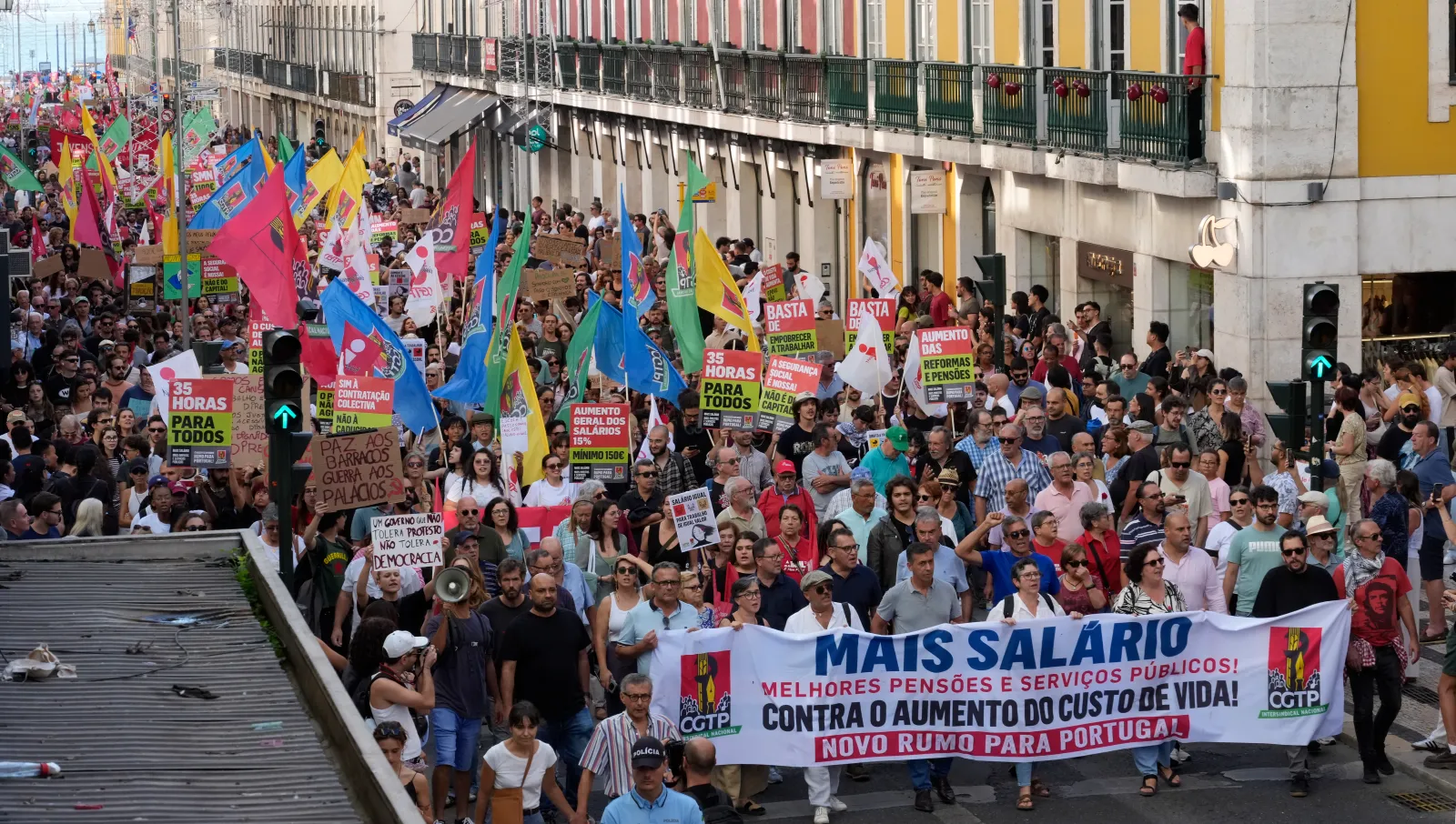 Participants hold signs and flags as thousands march at CGTP-IN decentralized national demonstration to demand higher wages, better pensions, and improved public services from Cais do Sodré to Rossio on October 17 in Lisbon.