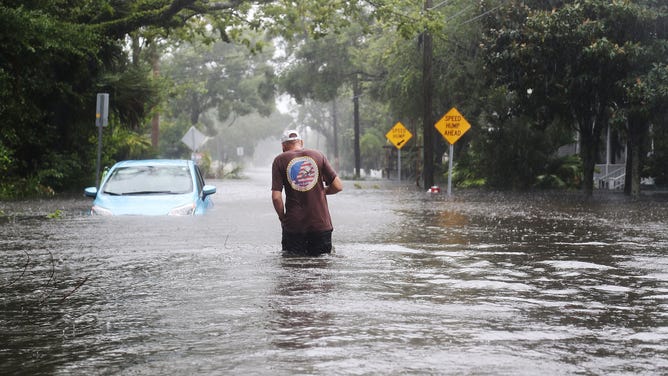 Man walks through the floods streets of St. Augustine, FL after Hurricane Matthew passed through the area on October 7, 2016.