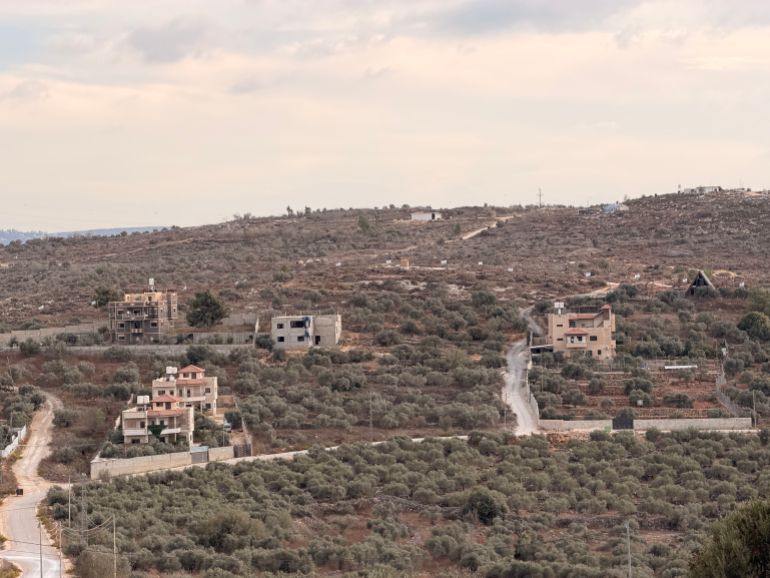 Israeli flags fly from Palestinian homes on the edge of Beita in the occupied West Bank as nearby outposts encroach on the town