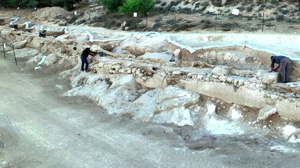View of archaeologists looking at ancient aqueduct