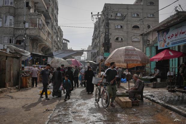 Palestinians walk through a market in the Al-Shati refugee camp in Gaza City.