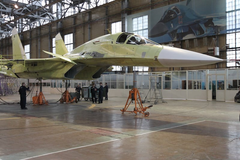 NOVOSIBIRSK, RUSSIA - MARCH 6: Men work on a Sukhoi SU-34, NATO, Fullback jet fighter-bomber as Russian President Vladimir Putin visits Novosibirsk Aircraft Production Association on March 6, 2013 in Novosibirsk, Russia. Putin is on a two day visit to Siberia. (Photo by Sasha Mordovets/Getty Images)