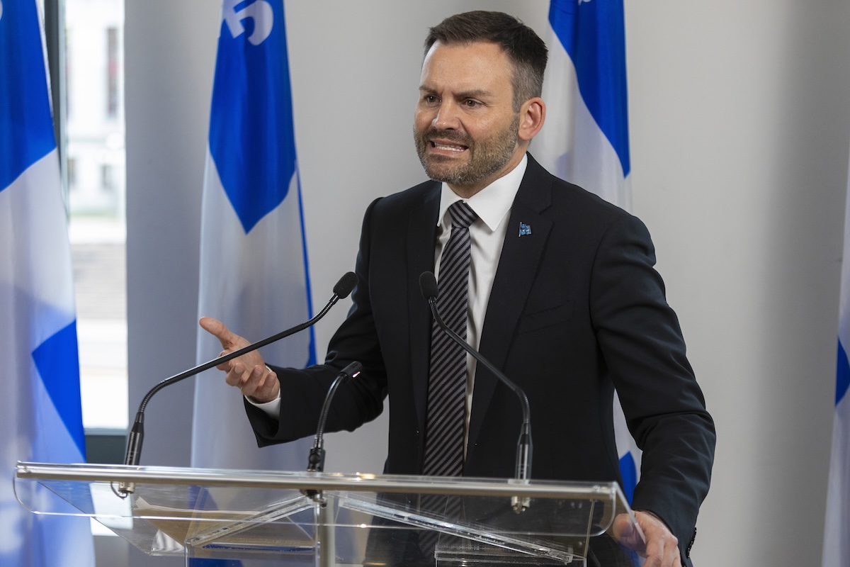 Man speaks into mic while on a podium