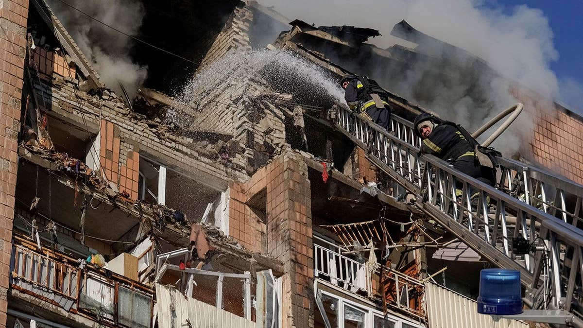 Firefighters work at the site of an apartment building damaged during a Russian drone strike