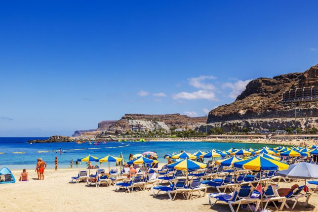 Rows of yellow and blue sun umbrellas and loungers at Gran Canaria, Las Palmas in Spain. A popular tourist attraction for UK holiday makers. (Photo: Alexander Shapovalov/Getty