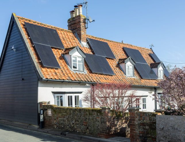Monocrystalline solar photovoltaic PV panels on steep roof of historic cottage building, Wickham Market, Suffolk, England, UK. (Photo by: Geography Photos/UCG/Universal Images Group via Getty Images)
