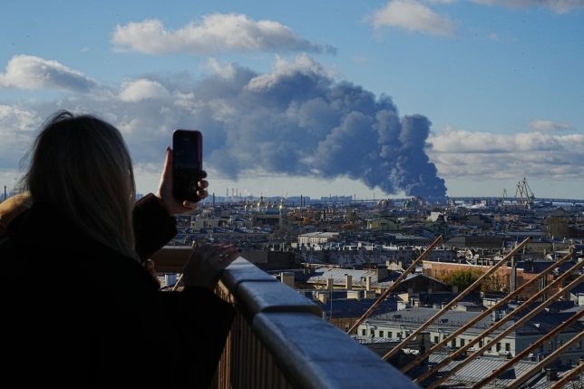 Smoke billows into the sky following Ukrainian drone strikes on an industrial zone in St. Petersburg, Russia, on Sunday, Oct. 18, 2026. (UGC via AP)