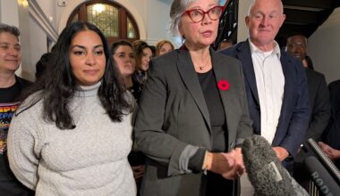 Three people &mdash; a young Indo-Canadian woman and a 60ish light-skinned woman and man &mdash; stand in a B.C. legislature hall.