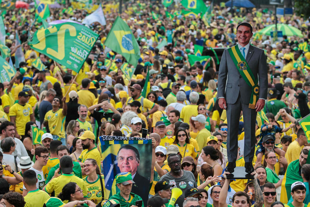 A poster featuring Flávio Bolsonaro at one of his final campaign rallies in Rio de Janeiro on Saturday (Photo: DOUGLAS SHINEIDR / AFP) ברזיל בחירות נשיאות עצרת סיום של תומכי פלאביו בולסונרו ריו דה ז'ניירו