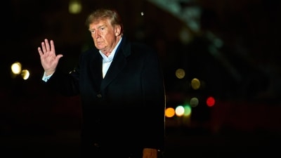 President Donald Trump waves to reporters as he walks across the South Lawn of the White House after stepping off Marine One, Sunday. (AP Photo)