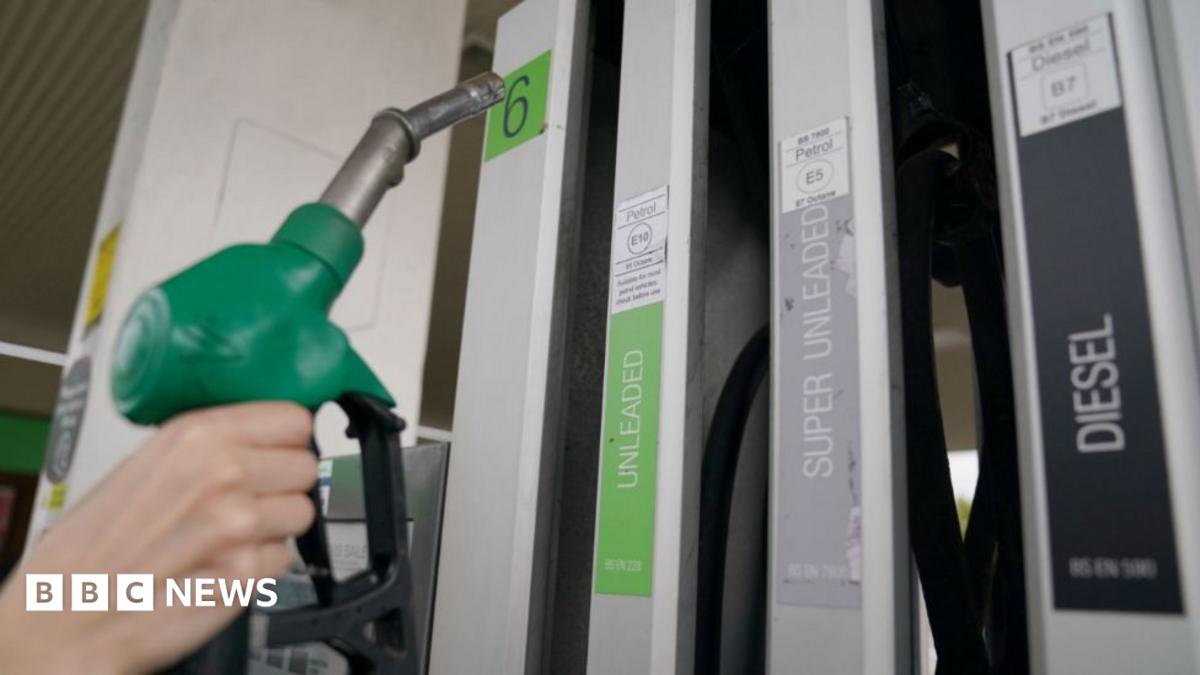 A petrol pump hose being taken from the pump