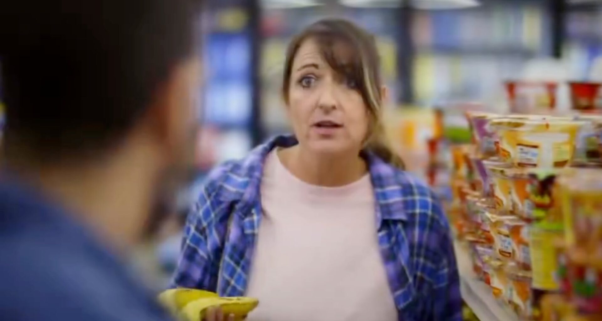 Actors playing a couple in a grocery store discuss inflation in a campaign ad