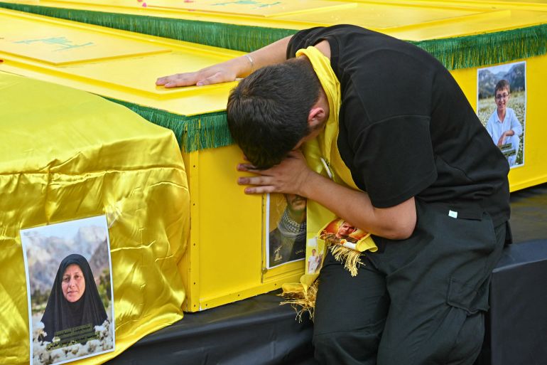 A mourner grieves over one of the coffins during the funeral of Ali Samir al-Haj Hassan, a commander in Hezbollah’s elite Radwan Force, in Beirut’s southern suburb on August 16, 2026, after he was killed a day earlier along with his family members in a strike carried out by Israel’s military in the village of Ansar [AFP]