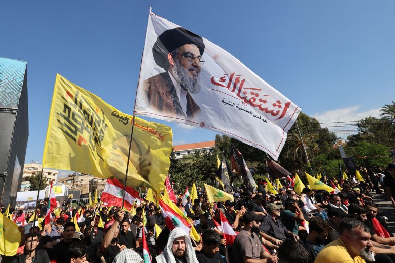Supporters of Lebanese Shia movement Hezbollah hold up a flag bearing the image of slain leader Hassan Nasrallah during a ceremony held to mark the second anniversary of Nasrallah's killing in a strike by Israel, in Beirut's southern suburbs on September 27, 2026.