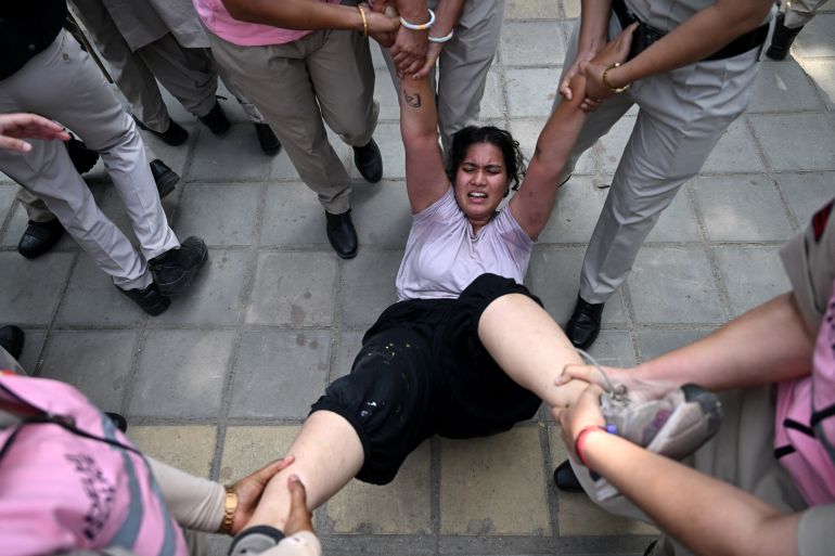 Police personnel detain a supporter of the Cockroach Janata Party (CJP) during a protest demanding the resignation of India’s Chief Election Commissioner Gyanesh Kumar over alleged voter roll irregularities linked to the "special intensive revision" (SIR), in New Delhi on October 10, 2026.