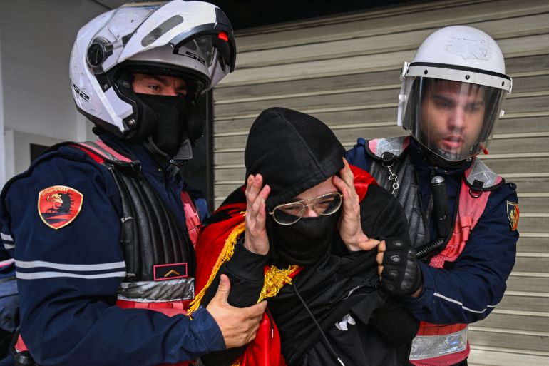 Police detain a protester during an anti-government demonstration in central Tirana on October 15, 2026, as protests continued for a third consecutive day over university conditions and demands for the resignation of Albanian Prime Minister Edi Rama.