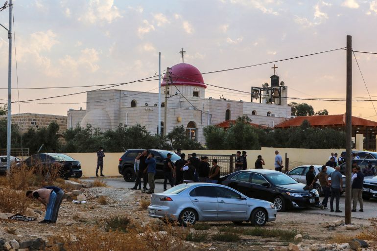 People and security forces gather outside a Greek Orthodox Church in the village of Hammoud in Jordan's Karak governorate following a shooting on October 23, 2026.