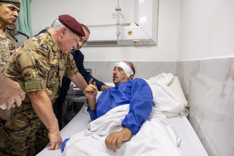 This handout picture released by the Jordanian Royal Palace on October 23, 2026, shows Jordan's King Abdullah II (L) visiting Prince Ali Military Hospital in Karak to check on those who were injured in the attack on a Greek Orthodox church in the village of Hammoud in Karak governorate.