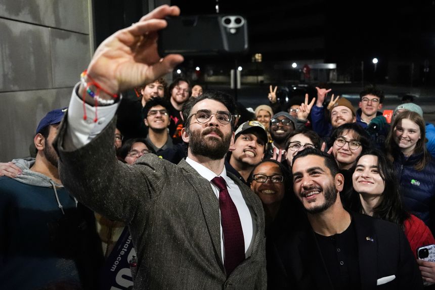 Streamer Hasan Piker, left, and Abdul El-Sayed, center right, take a selfie with young fans following a campaign event in April at the University of Michigan in Ann Arbor. Piker and El-Sayed visited both University of Michigan and Michigan State that day.