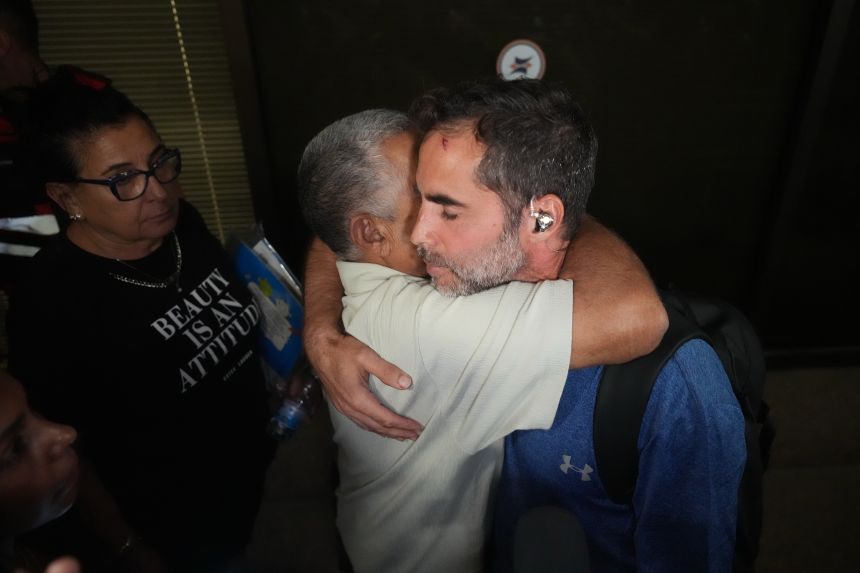 Israeli passenger Assaf Rajuan, right, who experienced an emergency landing in Saudi Arabia, during a flight on a Flydubai plane, hugs another passenger from the same flight as they arrive at Ben Gurion International Airport, near Tel Aviv, Israel, on Wednesday, Sept. 30.