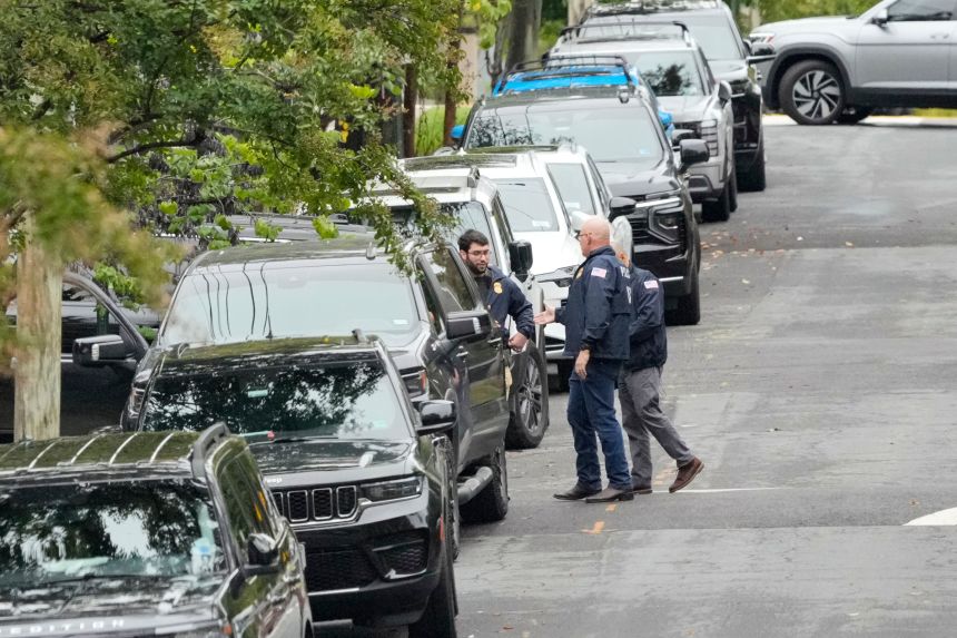 Homeland Security officers stand, during an investigation at the Washington, DC residence of Rep. Ilhan Omar, early Monday.
