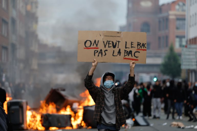A students holds a board reading, "we want the BAC (High School Diploma) Not the BAC (Anti-criminality units)" during a protest to demand more resources at school, in Lille, France, Thursday, Oct. 1, 2026. (AP Photo/Jean-Francois Badias)