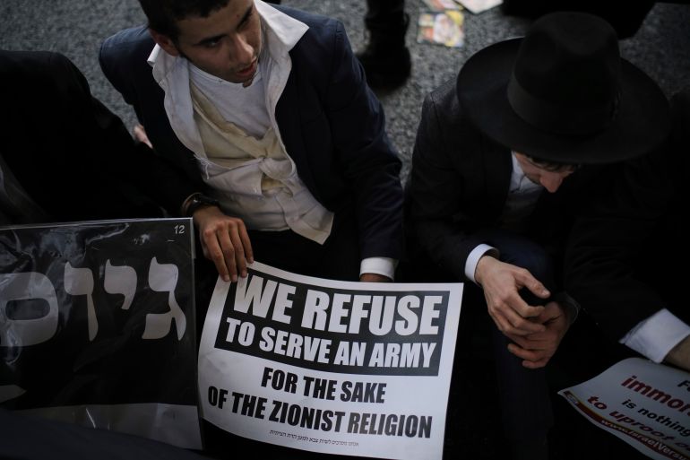 Ultra-Orthodox Jewish men block a highway during a protest against army recruitment in Bnei Brak, Israel, Thursday, June 5, 2025. (AP Photo/Leo Correa)