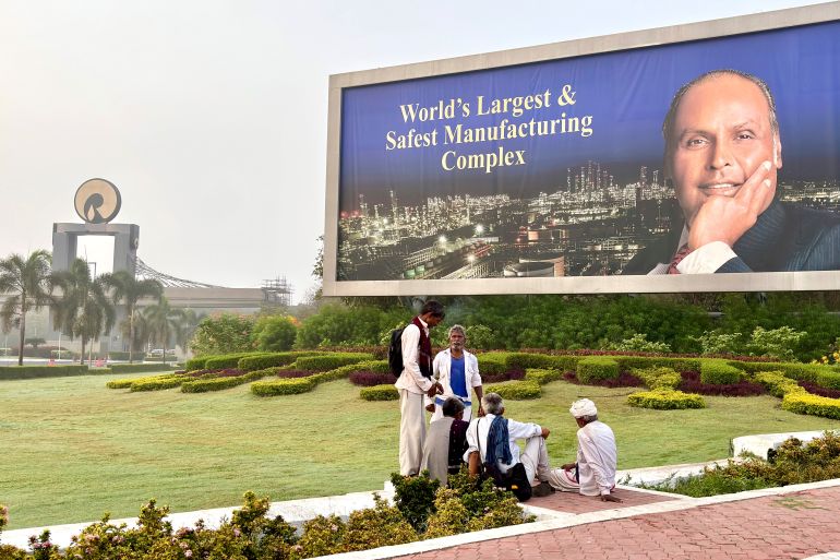 Villagers sit in the lawns outside the Jamnagar Refinery run by the Indian business conglomerate Reliance Industries, in Jamnagar, India, Wednesday, April 9, 2025. (AP Photo/Manish Swarup)
