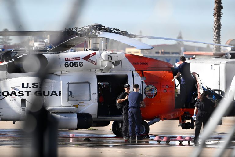Coast Guardsmen work on a helicopter at Coast Guard Station San Diego on Friday, Oct. 16, 2026. (AP Photo/Denis Poroy)