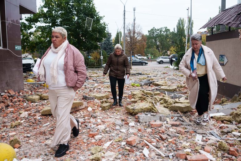 People walk in front of a multi-storey residential building damaged by a Russian drone strike on Kyiv, Ukraine, Wednesday, Oct. 21, 2026. (AP Photo/Evgeniy Maloletka)