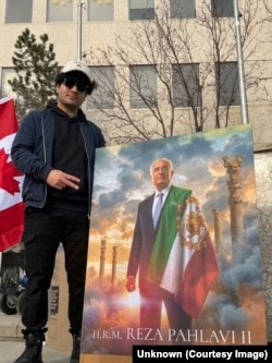Pourtalebian poses with a portrait of Iran's exiled former crown prince, Reza Pahlavi. He says his support of Pahlavi has made him a target.