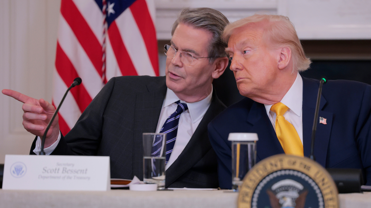 U.S. Secretary of Treasury Scott Bessent speaks with President Donald Trump at the White House.