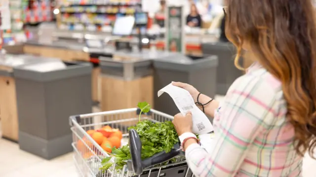 Woman checking her receipt after shopping at the grocery store