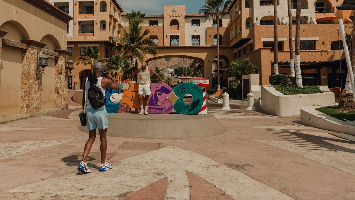 Tourists photograph in downtown Cabo San Lucas, Mexico.