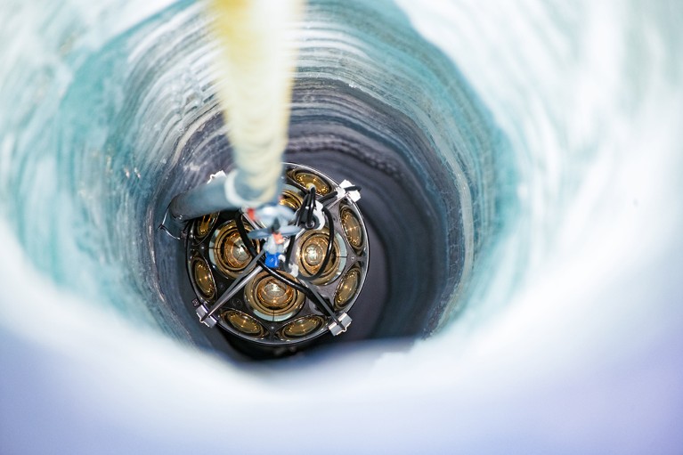A view of an mDOM being lowered into a borehole in the ice.