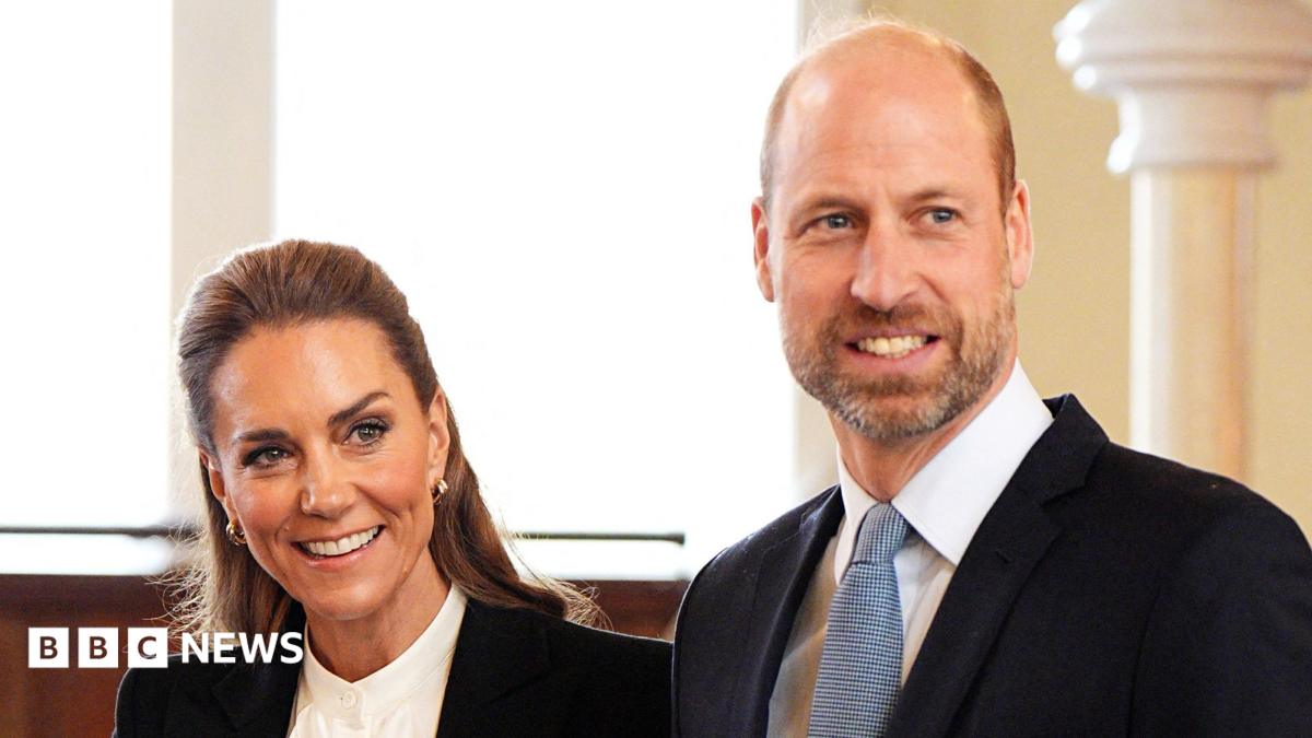 A woman with dark hair smiling and man with beard