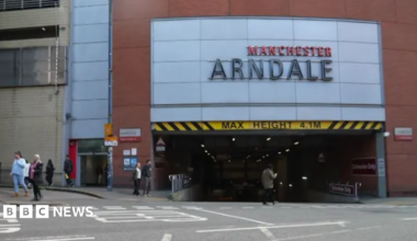 A sign to a shopping centre car park reads 'Manchester Arndale'.