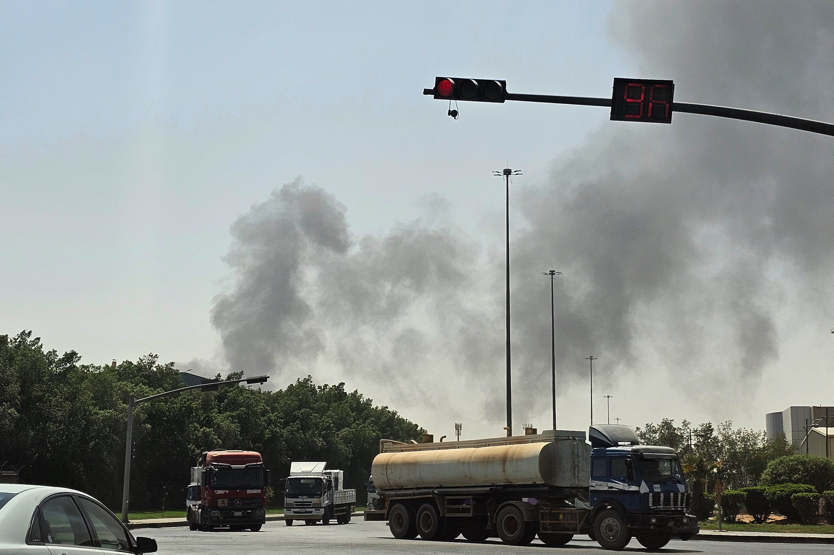 Vehicles travel along a road as black smoke billows from a fire at an oil facility in an industrial area in southern Riyadh, Saudi Arabia, Saturday, Oct. 3, 2026.