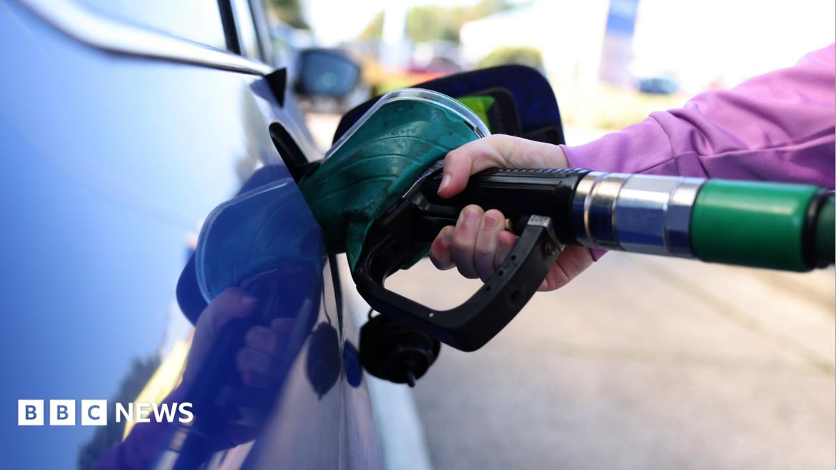 A close up shot of petrol being pumped into a blue car