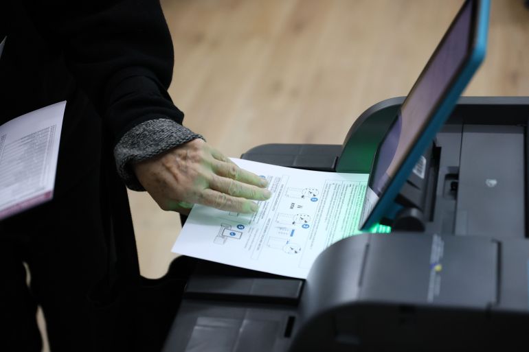 epa13280077 A voter feeds a paper ballot into an optical scanner at a polling station during the general election in Sarajevo, Bosnia and Herzegovina, 04 October 2026. Citizens across Bosnia and Herzegovina are voting to elect members of the country's tripartite presidency alongside national, entity, and cantonal representatives. The election also marks the first nationwide use of biometric fingerprint identification and ballot scanners to combat fraud. EPA/HAZIM ALJOVIC BOSNIA AND HERZEGOVINA OUT