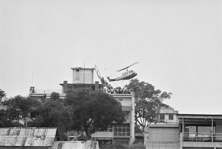 A helicopter is seen hovering over a building.