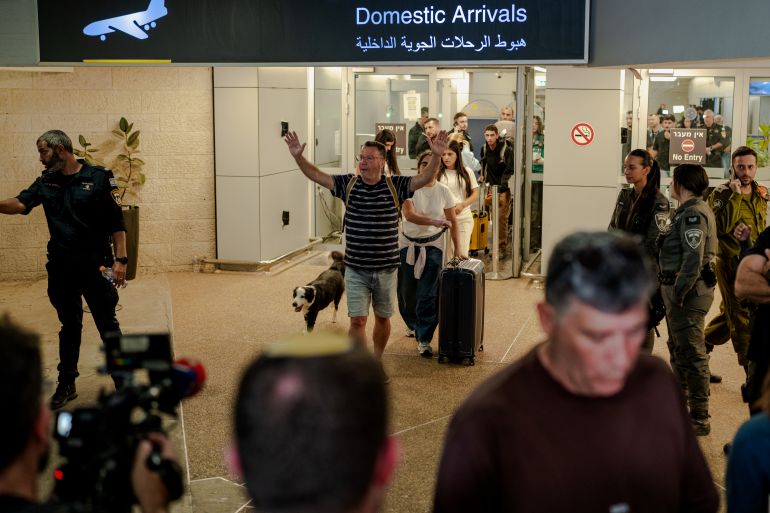 TZAFRIA, ISRAEL - SEPTEMBER 30: A passenger raises his arms in relief as he walks through the domestic arrivals doors with his dog and luggage at Ben Gurion Airport on September 30, 2026 in Tzafria, Israel. This morning, a Flydubai flight from Dubai to Tel Aviv was diverted to Saudi Arabia after a violent altercation in the cockpit. Passengers told media outlets that a pilot was stabbed and temporarily lost control of the plane. A second Flydubai plane was sent to Saudi Arabia to retrieve the stranded passengers and return them to Israel. (Photo by Erik Marmor/Getty Images)