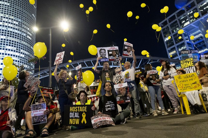 Supporters and families of hostages held in Gaza hold signs and photos of them during a demonstration calling for a hostage deal on April 3, 2024 in Tel Aviv.