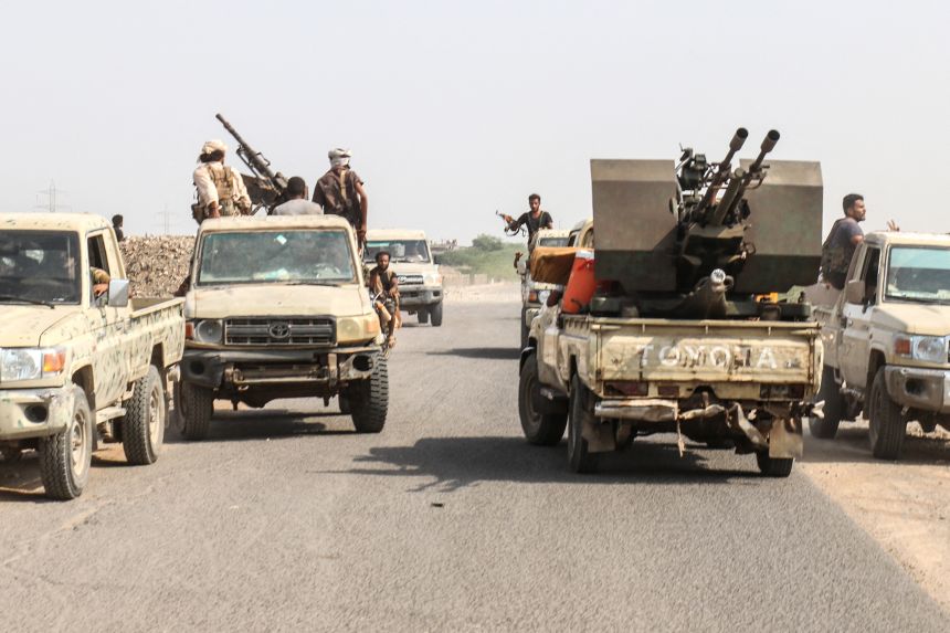 Forces loyal to Yemen's Saudi-backed government ride in pick-up trucks along a road in the Hays district, south of Hodeidah on September 5.