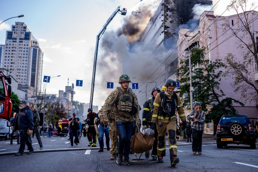 Firefighters and medics are evacuating an injured person after a projectile hit a residential building in the Kyiv city center on September 28, 2026.