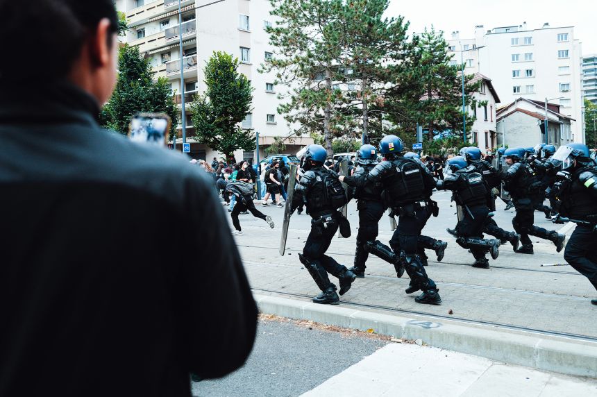 A teenager films with his mobile phone as police charge at demonstrators to disperse them on October 1 during the blockade of the Mounier secondary school in Grenoble, France.